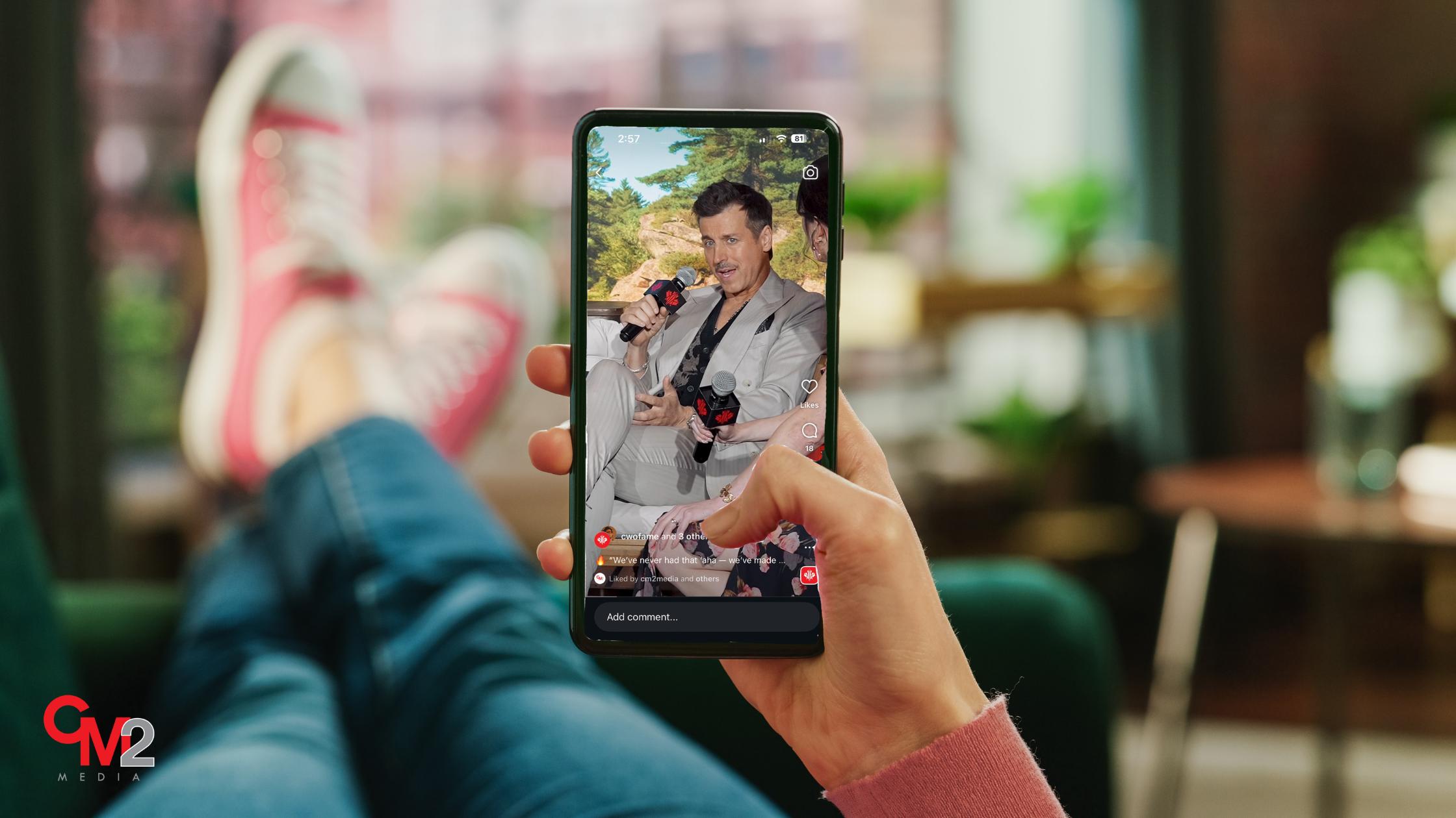 Faceless woman holding a phone watching a video - what are the benefits of video marketing - CM2 Media.