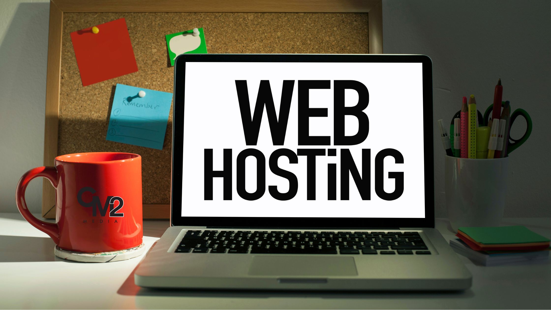 Laptop on a table with web hosting written on it with a red cup - website webhosting information - CM2 Media.