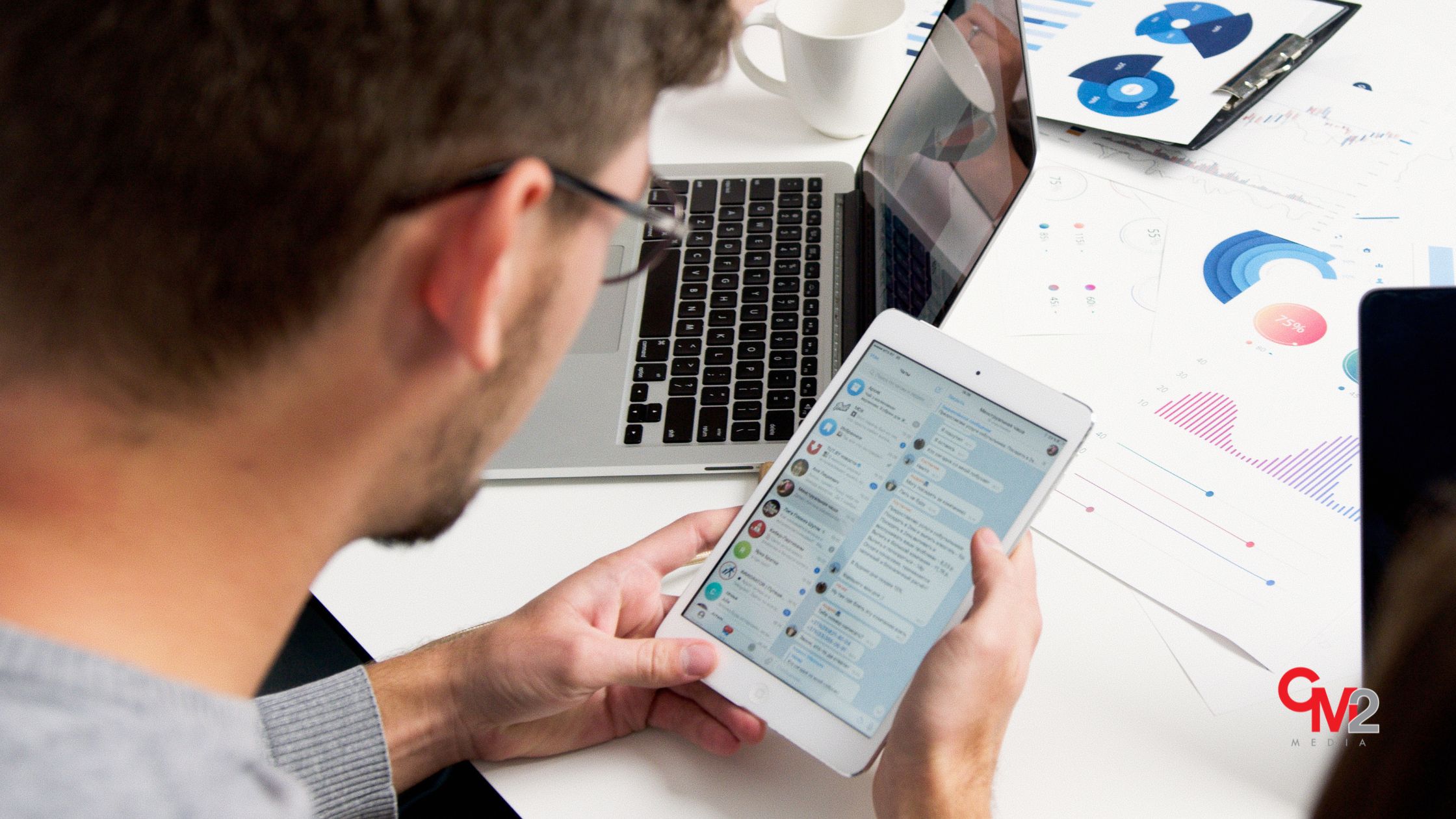 Faceless man looking at social media on a table - social media marketing for small business - CM2 Media.