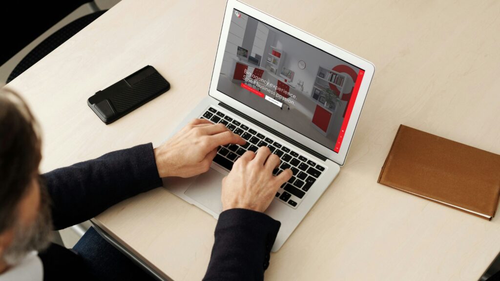 Faceless person typing on a laptop while looking at the CM2 Media website - website platform insights.